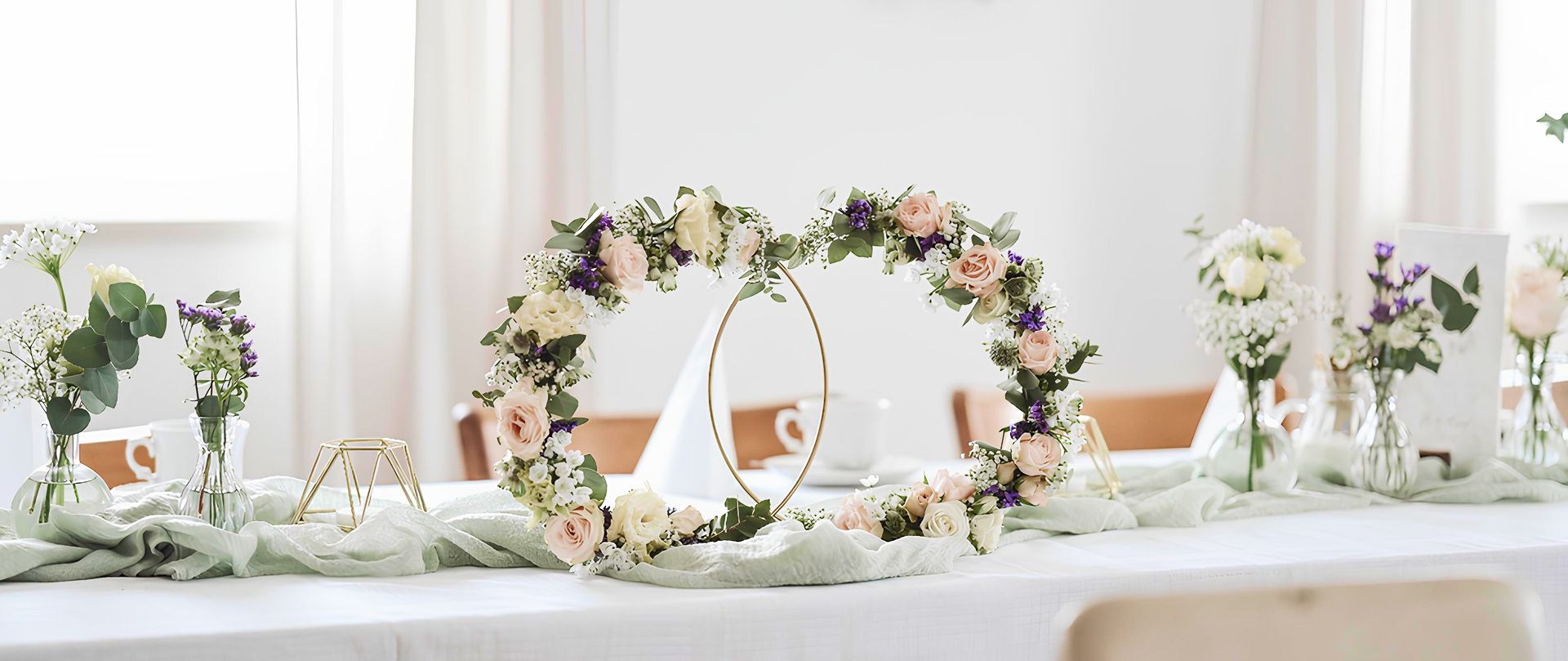 Festlich gedeckter Tisch mit Blumenarrangements und Dekoringen